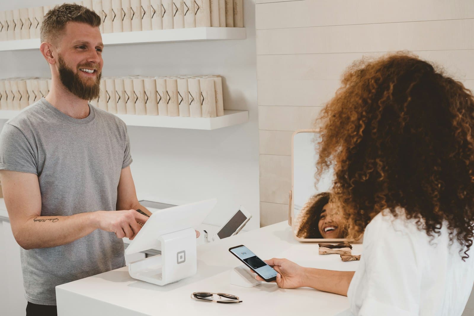 Customer paying by phone at a shop's point-of-sale counter