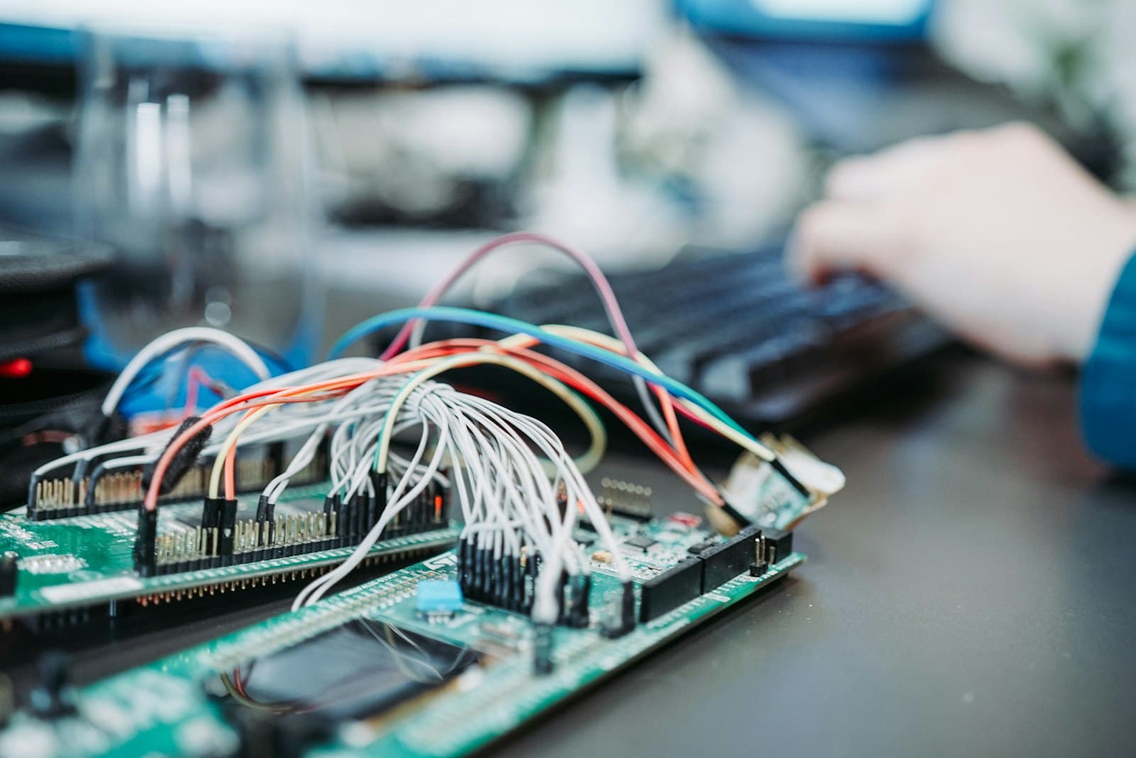 Microcontroller boards wired up on an engineer's desk
