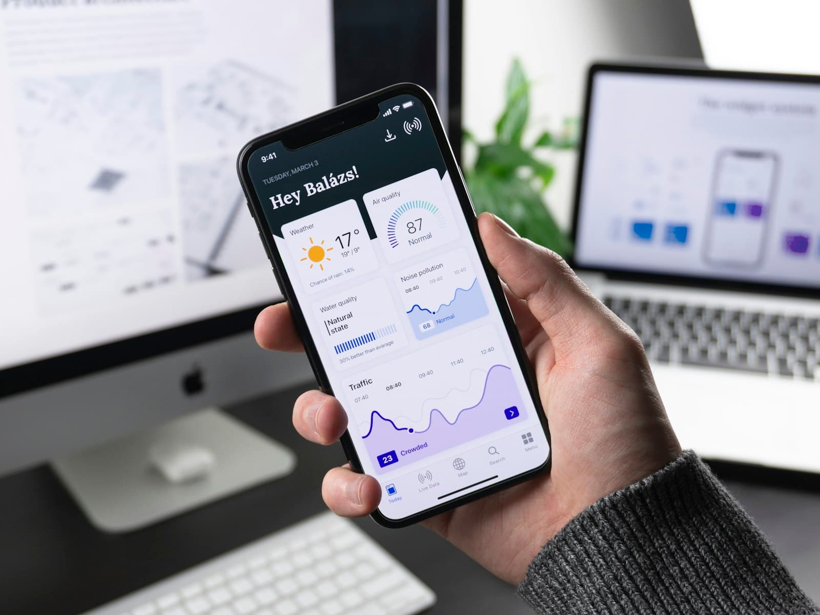 Hand holding a phone running a dashboard-style mobile app